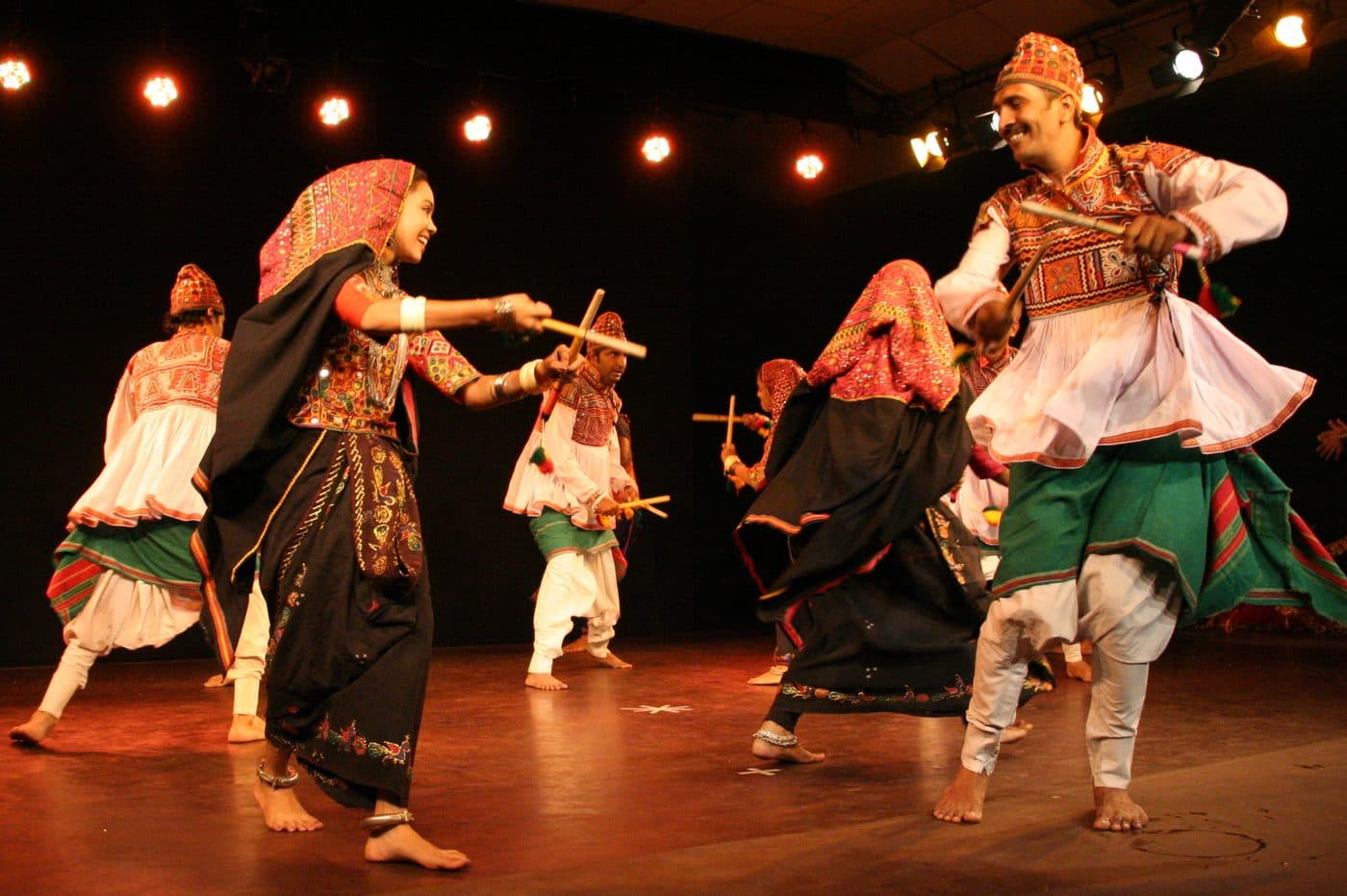 Dandiya dancers moving in a circle with sticks